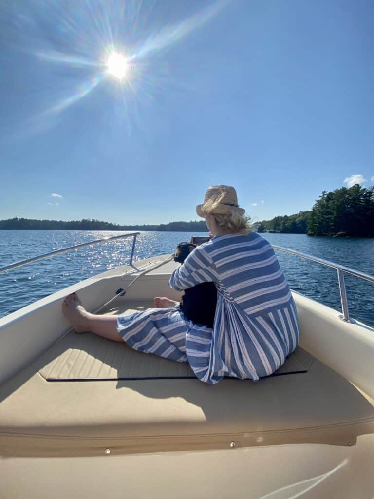 Woman sitting on a boat enjoying a sunny day on Muskoka Lake.