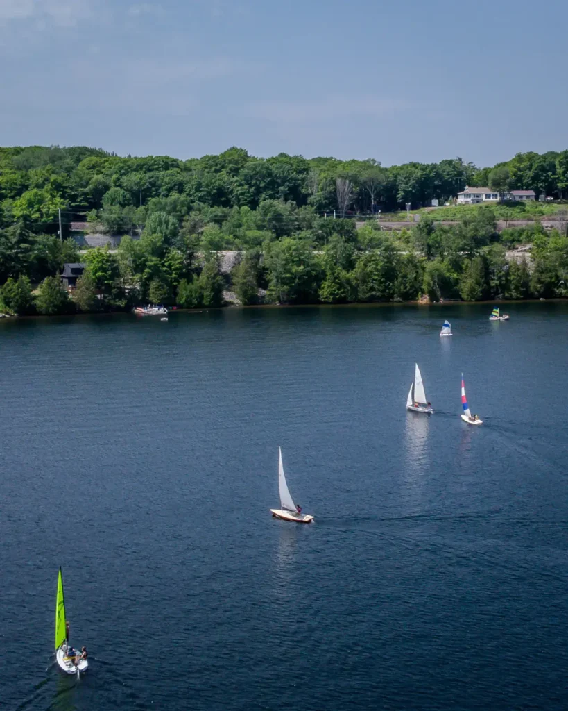 Sailboats on the water near the Lake Joseph Yacht Club during a summer sailing program.